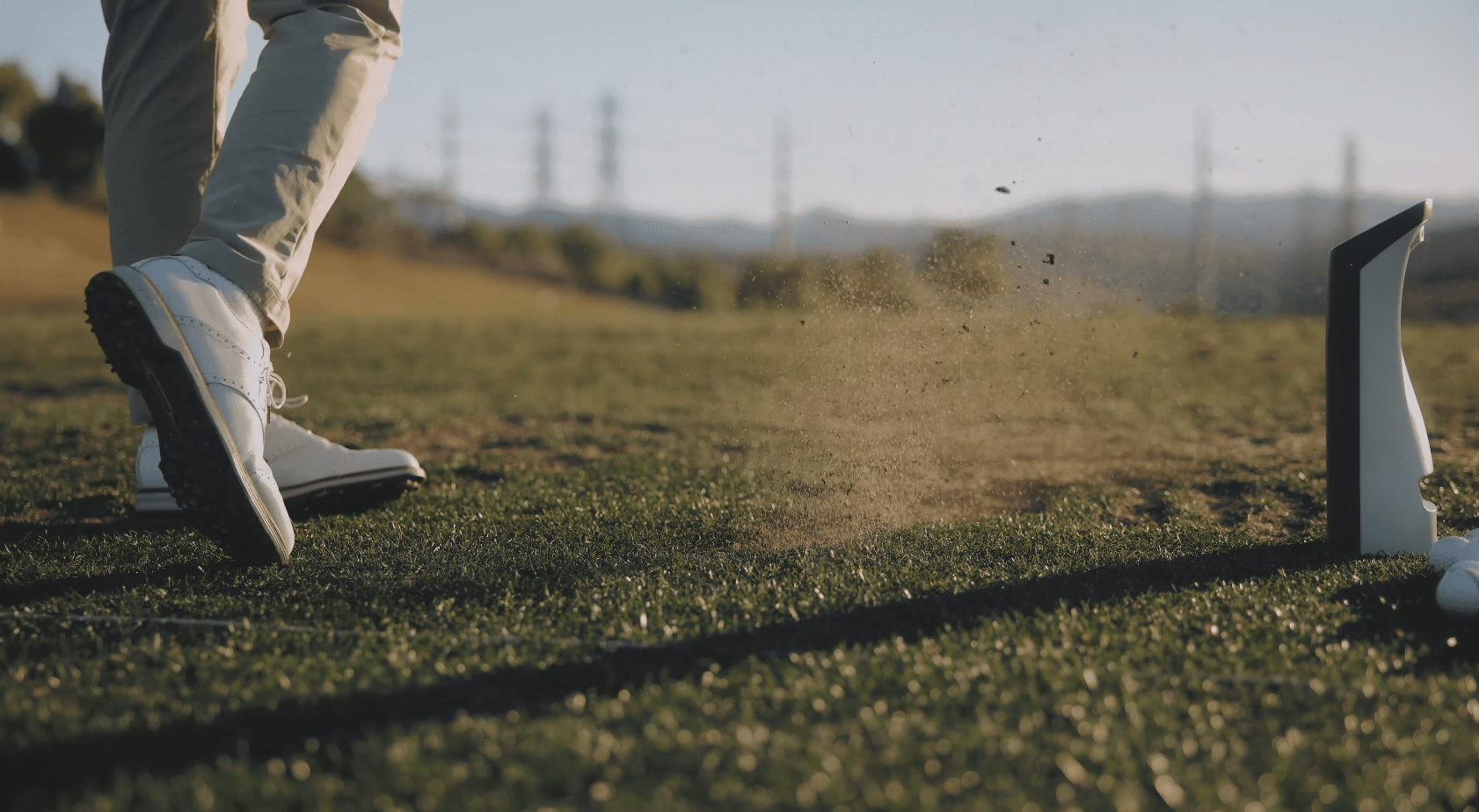 A man using the Spica 3 golf launch monitor on a golf course